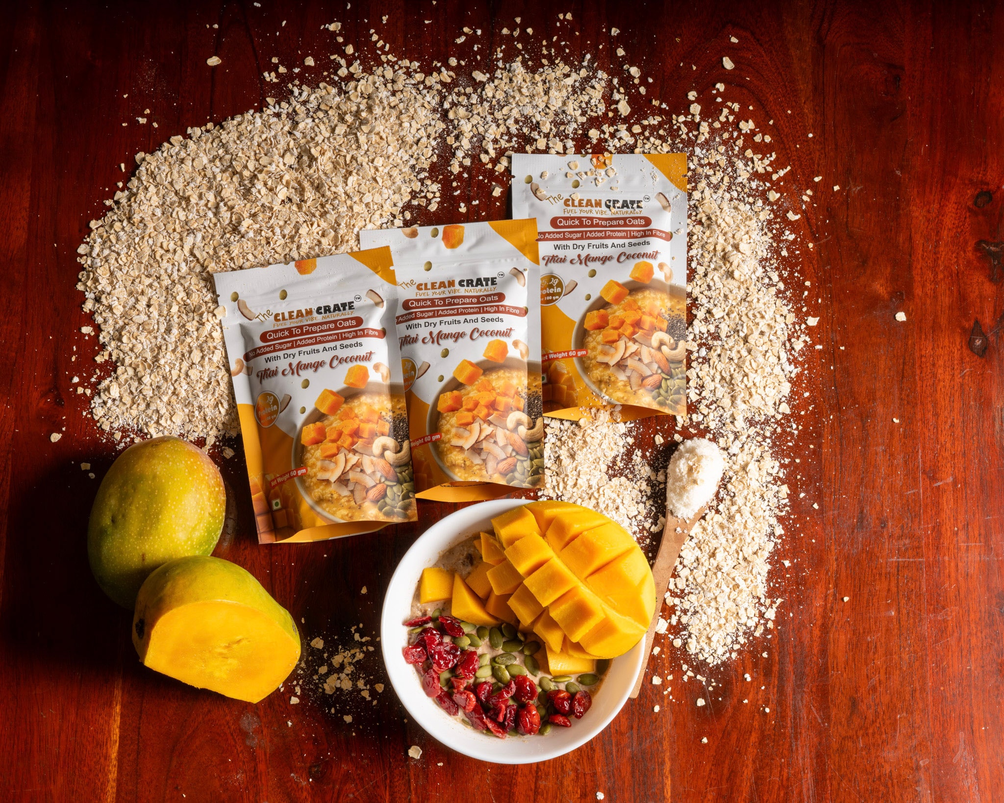 Mango, oats and packs arranged on a dark wooden surface